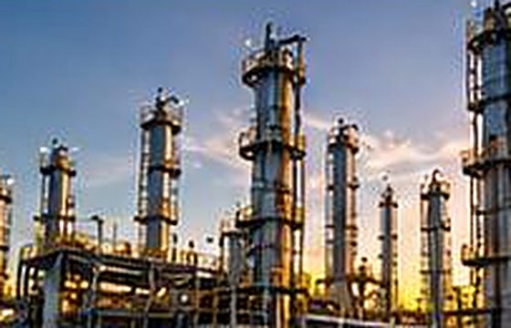 Process facility with columns and piping at dusk